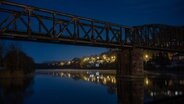 Die Eisenbahnbrücke in Hameln vor dunkelblauem Nachthimmel. © NDR Foto: Hubert Brenner