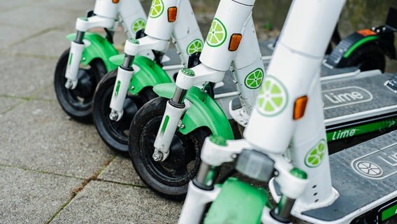 Vier E-Scooter von Lime stehen auf einem Fußgängerweg aneinandergereiht. © NDR Foto: Julius Matuschik