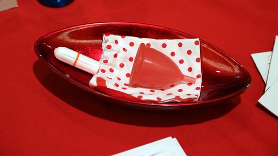 Ein Tampon und eine Menstruationskappe liegen in einer Schale. © NDR Foto: Eric Klitzke