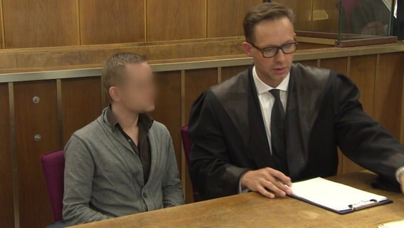 Zwei Männer sitzen auf der Anklagebank in einem Gerichtssaal des Landgerichts Hannover. © NDR 