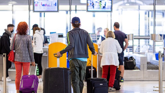 Menschen stehen am Flughafen am Check-In Schalter. © dpa-Bildfunk Foto: Moritz Frankenberg