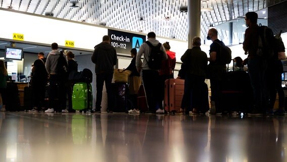 Urlauber stehen am Check-in Schalter am Flughafen Hannover. © dpa-Bildfunk Foto: Julian Stratenschulte