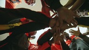 Fußballspieler legen die Hände übereinander. © NDR 