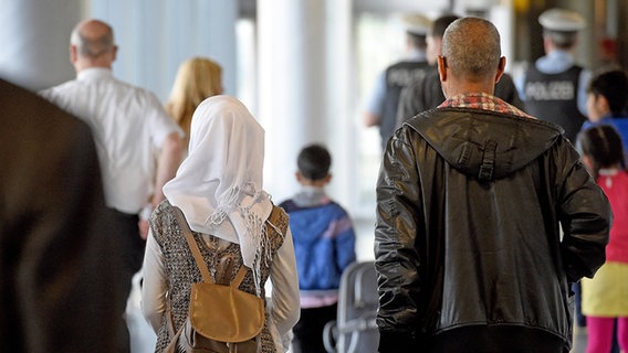 Mehrere aus Syrien geflüchtete Menschen laufen durch den Flughafen in Hannover. © dpa Foto: Holger Hollemann