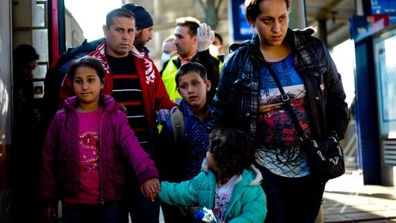 Flüchtlinge steigen auf dem Bahnhof in Lehrte aus einem Zug. Rund 420 Flüchtlinge sind mit einem Sonderzug von der österreichischen Grenze am Bahnhof in Lehrte eingetroffen. © dpa - Bildfunk Foto: Peter Steffen