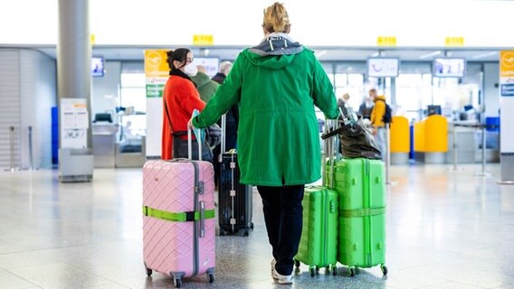 Fluggäste stehen mit Gepäck m Flughafen Hannover-Langenhagen am Check-in-Schalter. © picture alliance/dpa/Moritz Frankenberg Foto: Moritz Frankenberg