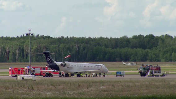 Ein Flugzeug steht auf einem Rollfeld am Flughafen Hannover umgeben von Feuerwehrwagen. © NonstopNews 