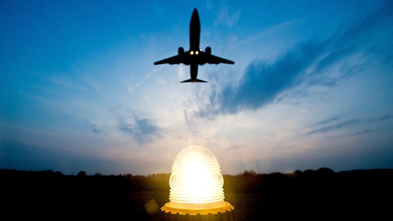 Eine Boeing 737-800 fliegt am Abend über die Anflugbefeuerung vom Flughafen Hannover. © dpa Foto: Christoph Schmidt