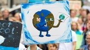 Ein Demonstrant der Bewegung Fridays For Future geht mit einem Plakat mit einer gezeichneten weinenden Erde durch Hannover. © dpa-Bildfunk Foto: Christophe Gateau/dpa