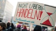 Bei einer Demonstration von "Fridays for Future" halten Demonstrierende ein Protestplakat mit der Aufschrift "Nicht Labern - Handeln" in die Luft. © NDR Foto: Julius Matuschik