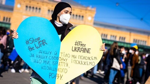 Die Schriftzüge «#stopthewar» und «#freeukraine» sind auf dem Plakat einer Demonstrantin auf einer Demonstration gegen den Angriff Russlands auf die Ukraine zu lesen. © dpa Foto: Moritz Frankenberg