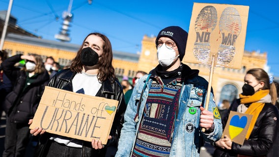 Die Schriftzüge "Hands off Ukraine" und "no war" sind auf den Plakaten von Demonstranten auf einer Demonstration gegen den Angriff Russlands auf die Ukraine zu lesen. © dpa Foto: Moritz Frankenberg