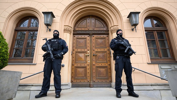 Bewaffnete Polizeibeamte stehen vor dem Gebäude des Oberlandesgerichts in Celle. © picture alliance/dpa Foto: Julian Stratenschulte