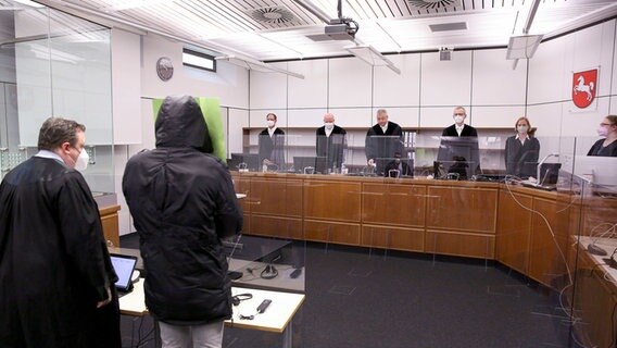 Ein Angeklagter steht neben seinem Anwalt in einem Gerichtssaal. © AFP-Pool Foto: Ronny Hartmann