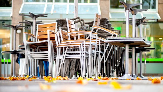 Stühle und Tische eines geschlossenen Restaurants sind aufeinander gestapelt. © Picture Alliance Foto: Hauke-Christian Dittrich