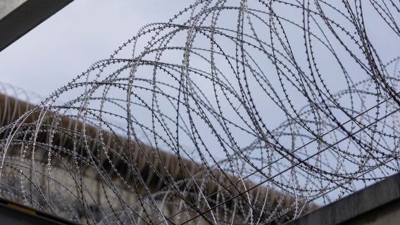 Ein Stacheldrahtzaun in einem Gefängnis © picture alliance / imageBROKER Foto: Sylvio Dittrich