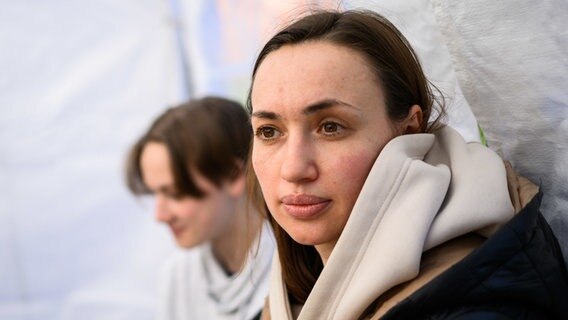 Die geflüchtete Bila (r) und ihr Sohn Max aus Kiew sitzen nach ihrer Ankunft in Deutschland an der ukrainisch-katholischen Kirche St. Wolodymyr. © dpa Foto: Julian Stratenschulte