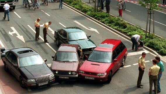 Drei Fahrzeuge der Polizei stehen eines der Fluchtfahrzeuge umzingelnd auf der Straße. Vor 20 Jahren, am 23. Mai 1995, hatte die Polizei eine Geiselnahme in Celle nach 51 Stunden unblutig beendet. © dpa Foto: Holger Hollemann