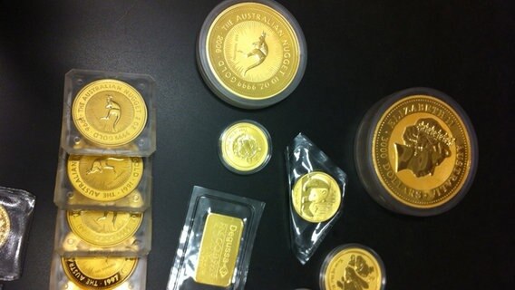 Verschiedene Goldmünzen liegen auf schwarzen Untergrund. © NDR 