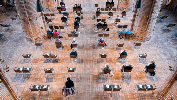 Menschen sitzen am Karfreitag mit Abstand in der Marktkirche in Hannover und nehmen an einem Gottesdienst teil. © dpa-Bildfunk Foto: Julian Stratenschulte
