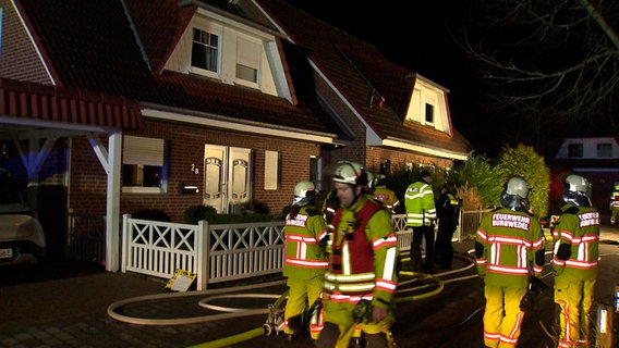 Einsatzkräfte der Feuerwehr stehen vor einem Haus. Einsatzkräfte der Feuerwehr stehen vor einem Haus. © NonstopNews