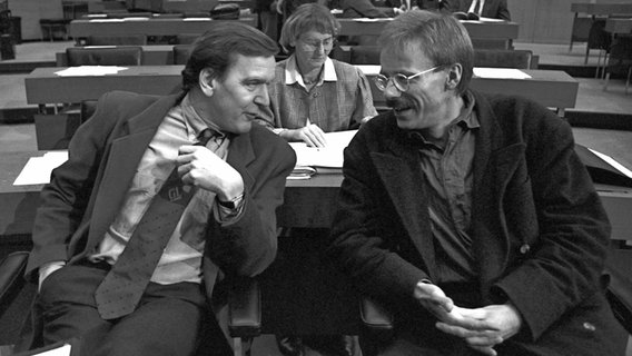 Die rot-grünen Oppositionschefs Gerhard Schröder von der SPD (l.) und Jürgen Trittin von den Grünen sitzen am 13.12.1989 im Landtag in Hannover nebeneinander, um ihre Ansichten auszutauschen. © picture-alliance Foto: Holger Hollemann