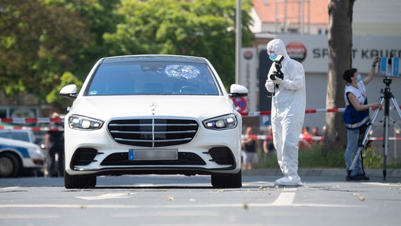 Ein Mitarbeiter der Spurensicherung fotografiert einen Mercedes mit Einschußloch in der Frontscheibe. © dpa-Bildfunk Foto: Julian Stratenschulte