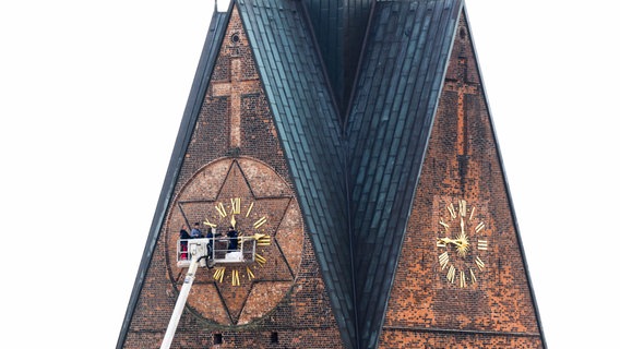 Handwerker montieren die goldenen Zeiger der Kirchturmuhr an der Marktkirche in Hannover. © dpa-Bildfunk Foto: Julian Stratenschulte