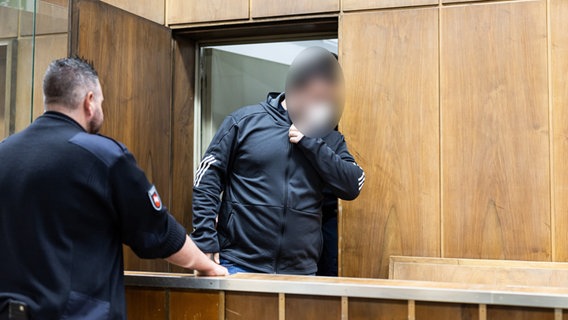 Der Angeklagte (M) sitzt vor Prozessbeginn in einem Gerichtssaal im Landgericht Hannover. © dpa-Bildfunk Foto: Michael Matthey