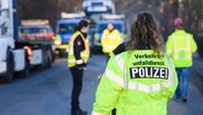 Polizeibeamte stehen an einer Unfallstelle in Hannover, an der ein Lkw einen Pförtner überrollt hat. © dpa Foto: Julian Stratenschulte