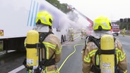 Feuerwehrleute löschen einen brennenden Lkw-Auflieger auf der A2. © Hannover Reporter 