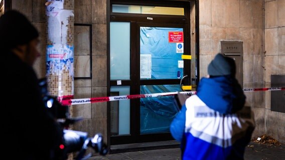 Eine Polizei-Pressesprecherin steht in der Nacht vor dem polizeilich versiegelten Eingang einer Spielothek. © dpa Foto: Moritz Frankenberg