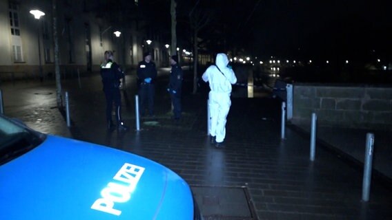 Ein Polizeiwagen, Polizisten und ein Mensch in weißem an einem Tatort am Leineufer in Hannover. © TeleNewsNetwork 