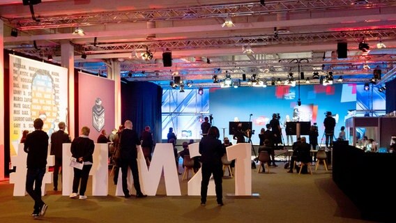 Menschen stehen an einem Studio für die Übertragung der digitalen Version der Hannover Messe. © dpa-Bildfunk Foto: Julian Stratenschulte