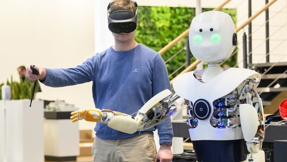 Ein Mann führt auf der Industriemesse Hannover Messe am Messestand des Elektronikunternehmens Wago einen ferngesteuerten Roboter vor. © Julian Stratenschulte/dpa Foto: Julian Stratenschulte/dpa