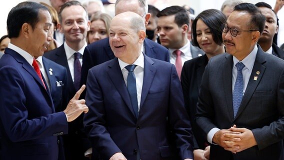 Il cancelliere Olaf Schultz (SPD, M) ride accanto a Joko Widodo (L), presidente dell'Indonesia, in uno stand davanti a un manichino durante il round di apertura della Fiera dell'industria di Hannover.  © dpa-Bildfunk Foto: Michael Matthey