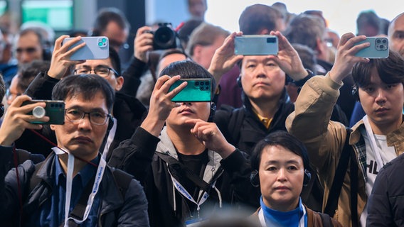Messebesucher filmen und fotografieren mit ihren Smartphones am Stand von Siemens bei der Hannover Messe 2024. © dpa-Bildfunk Foto: Julian Stratenschulte