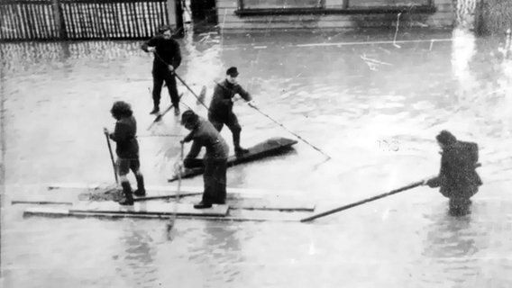 Menschen fahren auf Flossen auf vom Hochwasser überfluteten Straßen in Hannover. © NDR 