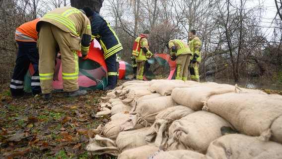 Helfer von der Feuerwehr und Technischen Hilfswerk (THW) installieren in Sarstedt ein mobiles Hochwasserschutzsystem. © dpa Foto: Julian Stratenschulte
