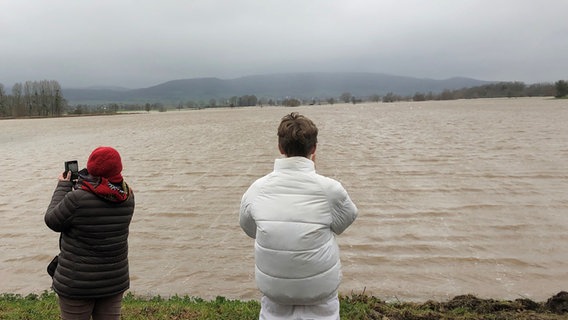Menschen fotografieren das Weser-Hochwasser bei Hessisch Oldendorf. © NDR Foto: Wilhelm Purk