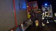 Menschen mit Tauchausrüstung steigen in ein Feuerwehrauto. © Nord-West-Media TV 