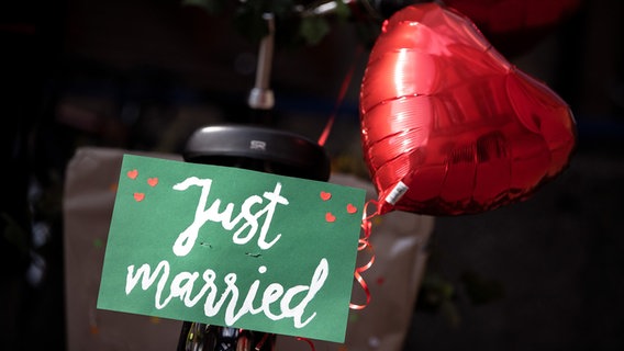 "Just married" steht auf einem Schild, das an einem Fahrrad befestigt ist. © picture-alliance/dpa Foto: Sina Schulte