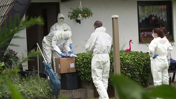 Mitarbeiter der Spurensicherung stehen vor einem Haus in Holtensen. © picture alliance/dpa 