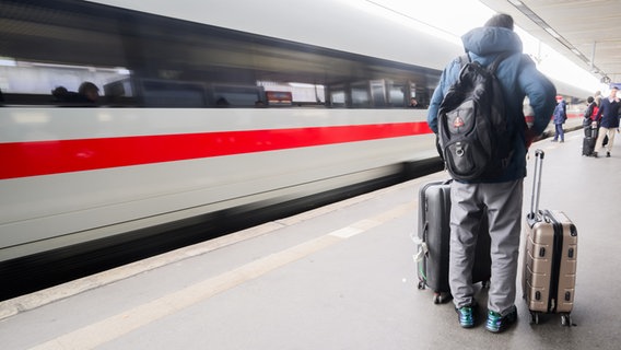Ein Mann steht mit Koffern auf dem Bahnsteig im Hauptbahnhof Hannover. Ein ICE fährt ein. © picture alliance/dpa | Julian Stratenschulte Foto: Julian Stratenschulte