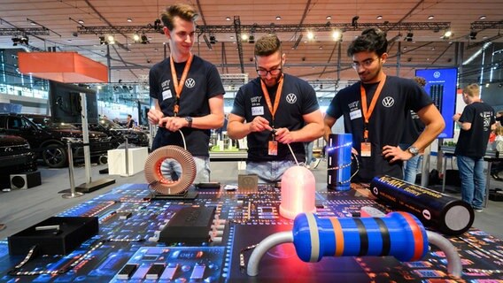 Sean (von links nach rechts), Felice und Görkem spielen bei der IdeenExpo in der Messe Hannover am Stand von VW ein Rennen mit LED-Lampen. stehen bei der Eröffnung der IdeenExpo in der Messe Hannover. © dpa Foto: Julian Stratenschulte