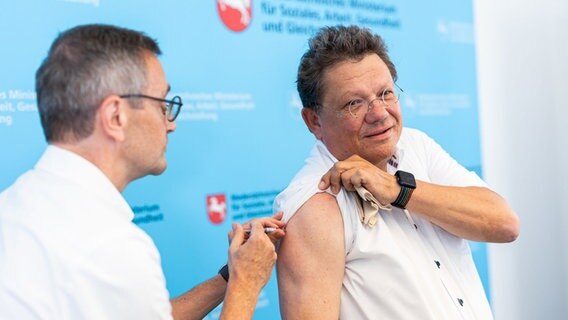 Andreas Philippi (SPD, r), Gesundheitsminister von Niedersachsen, erhält im Niedersächsischen Gesundheitsministerium eine Grippeschutzimpfung gegen Influenza. © Michael Matthey/dpa Foto: Michael Matthey