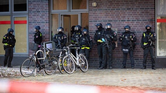Einsatzkräfte der Polizei sind in einem abgesperrten Bereich vor einem Jobcenter im Einsatz. © Moritz Frankenberg/dpa Foto: Moritz Frankenberg