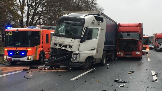 Ein Feuerwehreinsatzwagen steht neben mehreren beschädigten Lkw auf der Autobahn © Hannover Reporter Foto: Amadeus Sartorius