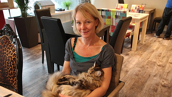 Inhaberin Astrid Heyer mit Katze "Havanna" auf dem Schoß. © NDR Foto: Inga Mathwig