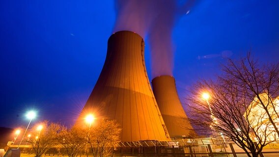 Aus den Schornsteinen des Kernkraftwerks Grohnde zieht in der Dämmerung Rauch auf. © dpa - Bildfunk Foto: Julian Stratenschulte